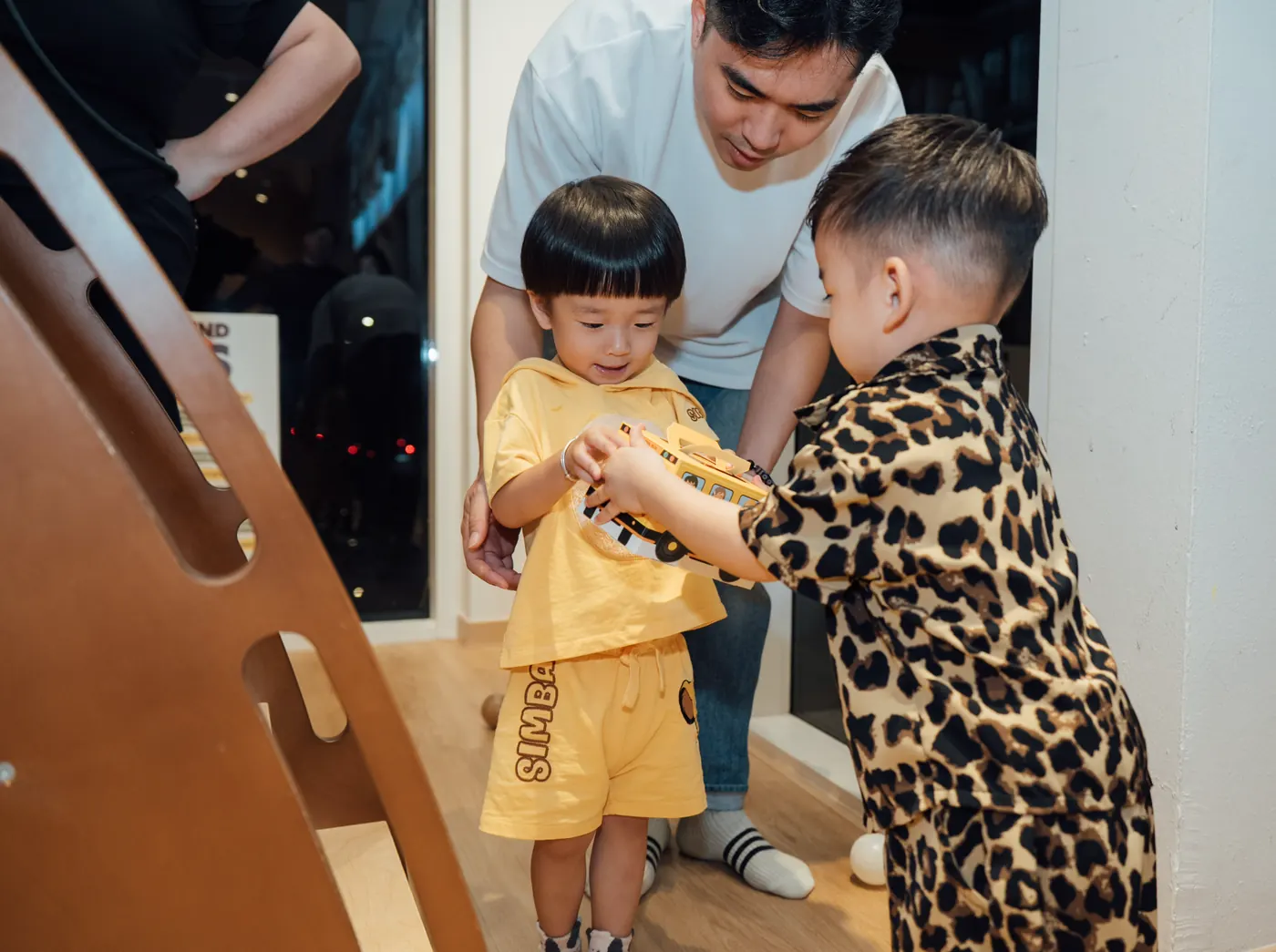Jordan handing a door gift to another child at his second birthday party at Naru.