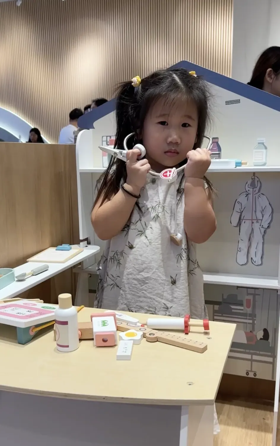 A child at Naru in a dress-up costume, deep in a pretend-play role.